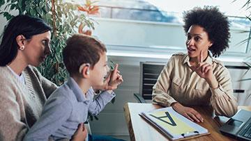 American Sign Language Professional working with a child and his guardian.